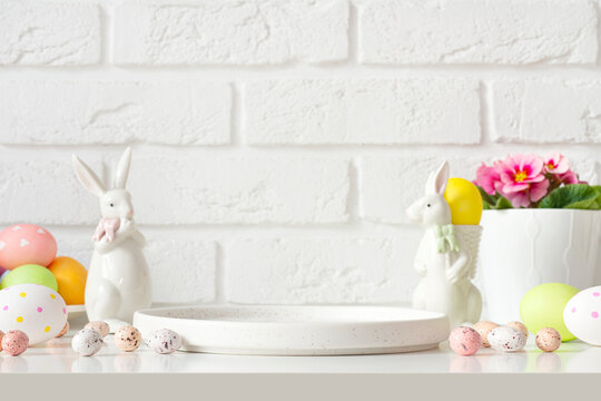 Podium plate on table for product display surrounded by easter bunnies, eggs and flowers