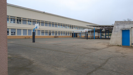 Fototapeta na wymiar School building exterior primary schoolyard with basketball court