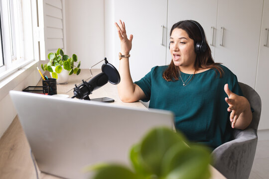 Young biracial woman records a podcast from home