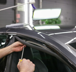 Removing dents on the car. PDR technology. Car body repair without painting. A specialist repairs a...