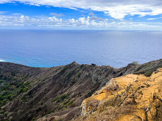 Fototapeta premium Hawaiian landscapes view from the top of the old volcano. The view from the top of Hawaiian volcano on the Oahu Island. Turquoise sky above island volcanic nature. Waikiki is way down underneath.
