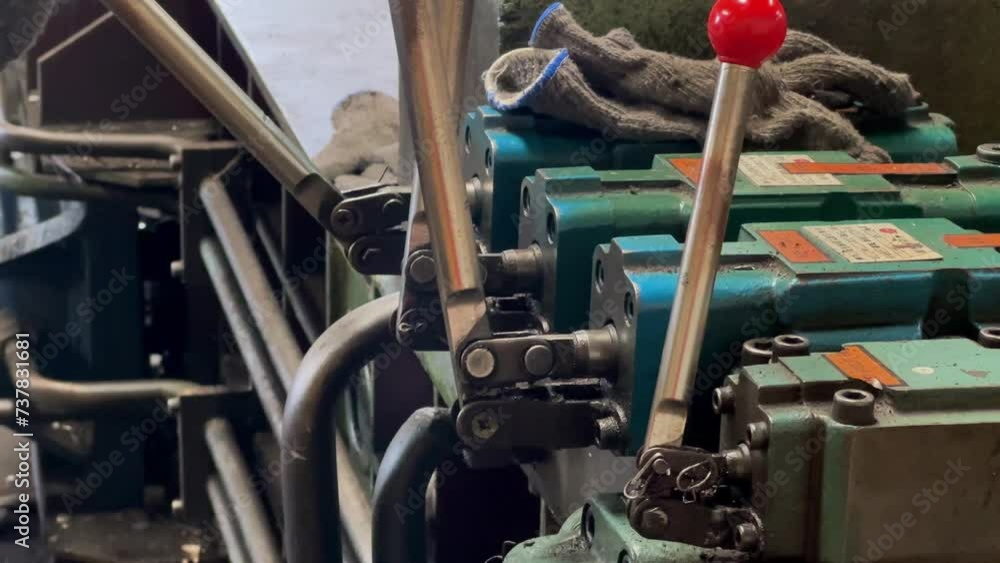 Poster manually operated machine lever by hand. the machine operator is moving the lever.