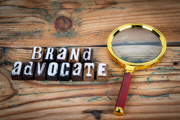 BRAND ADVOCATE. Alphabet letters on wood texture background
