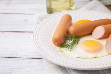 Delicious boiled sausages, fried eggs and dill on wooden table, closeup