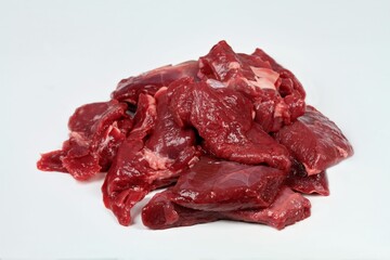 Raw deer meat ready for cooking venison ragout or goulash.  Pieces of game meat on the white background. 