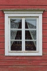 White framed window on old red painted wood wall.