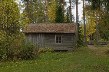 Old wooden building in forest in autumn.