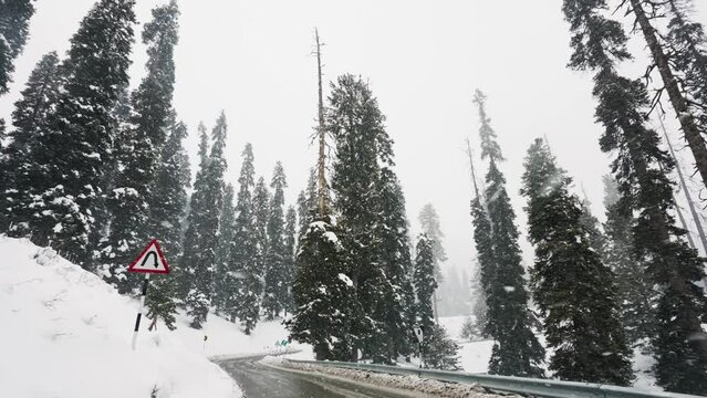 Driving On Curved Road During Snowfall In Winter. Gulmarg, Jammu And Kashmir, India. low angle, slow motion