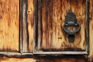 Detail embossed metal handle and an old door