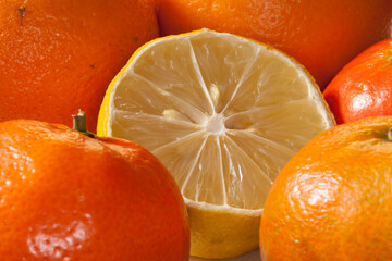 Citron entamé entouré d'oranges et de mandarines