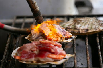Cooking seafood at a food stall at the Tsukiji Outer Market in the city of Tokyo, Japan.