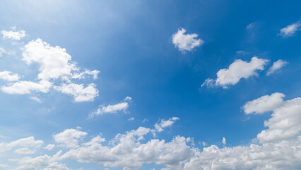Naklejka na ściany i meble Panoramic view of clear blue sky and clouds, Blue sky background with tiny clouds. White fluffy clouds in the blue sky. Captivating stock photo featuring the mesmerizing beauty of the sky and clouds.