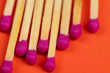 matches with a red pink substance for lighting on an orange background