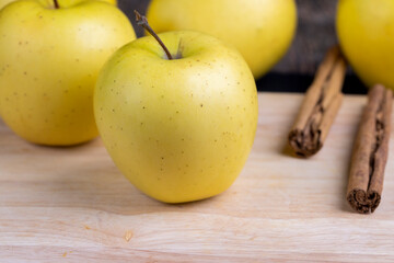yellow ripe apple with cinnamon on the table