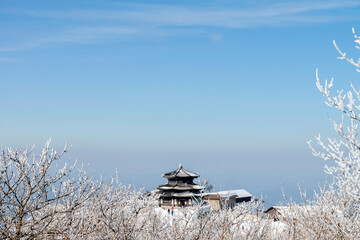 a traditional Korean building on the top of the snow-covered mountain