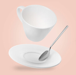 Spoon, cup and saucer falling on pale pink background