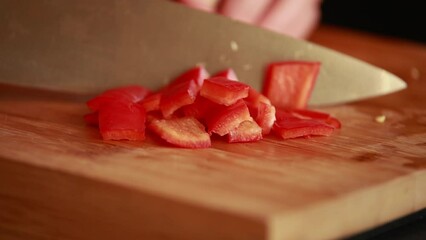culinary finesse: woman hands cutting fresh red bell peppers on wooden board close-up