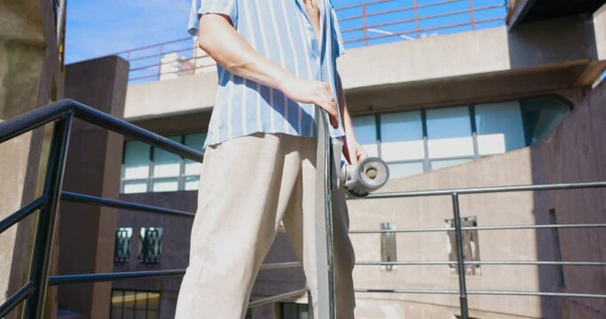 Young handsome man holding skateboard 