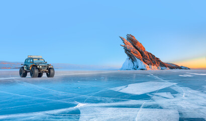 Ogoy island on winter Baikal lake with transparent cracked ice - A moving a thick-wheeled suv car...