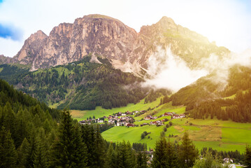Dolomite alps with a mountain village and green meadows