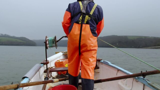 Winding in the dredge from the punt alternative angle from behind