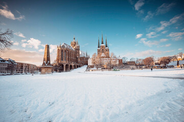 Der Erfurter Domplatz ist bedeckt von Schnee. In den frühen morgen Stunden, während des Sonnenaufgangs glänzte der Dom und St. Severi in strahlendem Licht, erhaben auf dem Domberg.