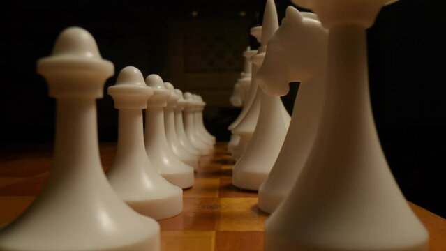 Capturing precision, a macro dolly shot zooms in on white chess pieces, illustrating strategic maneuvers on the intense battleground