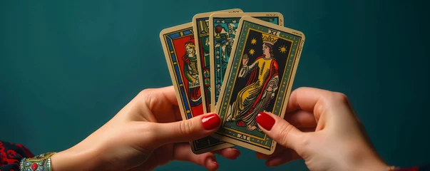 Fotobehang Hands holding 4 beautiful tarot and oracle card on dark green background, inviting users to seek guidance, self-reflection, and spiritual insights. These cards serve as powerful tools for divination. © Holly Berridge