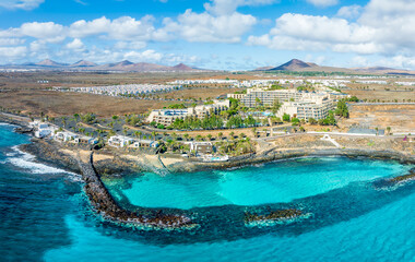 Overlook the serene Playa El Ancla in Costa Teguise, Lanzarote, where crystal-clear waters and...
