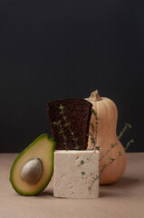 Delicious ready to eat plant-based food minimalist art or background with squash bread avocado tofu and sign black and beige colors