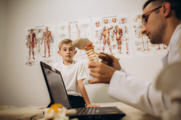 Obraz premium Professional orthopedist examining little patient's leg in clinic