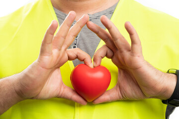 Close-up of builder holding red heart making love gesture