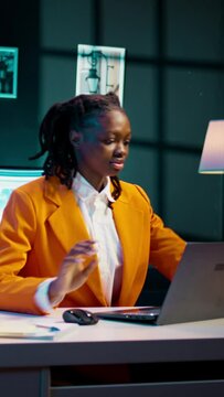 Vertical Video African american student working on her bachelor paper essay at home, writing ideas from online research. Girl exploring digital libraries and academic databases for additional