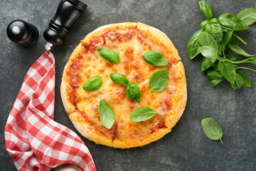 Margarita pizza. Traditional neapolitan margarita pizza and cooking ingredients tomatoes basil on old concrete texture background table. Italian Traditional food. Top view. Mock up.