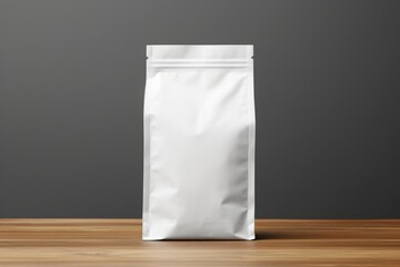 A blank white pouch for product mockup stands on a wooden surface against a dark background.