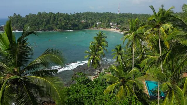 Tropical ocean lagoon with palms and turquoise water with waves good for surfing and full of surfers