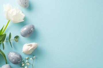 Easter décor snapshot: top view shot of grey eggs, bunny ornament, gypsophila, tulip, and...