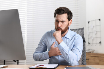 Naklejka premium Sick man coughing at workplace in office. Cold symptoms