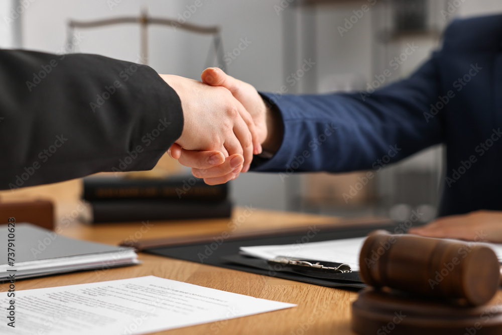 Canvas Prints Notary shaking hands with client at wooden table in office, closeup