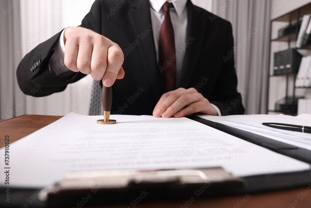 Canvas Prints Notary stamping document at table in office, closeup