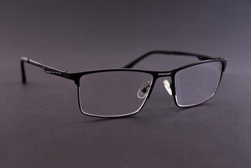 Black metal frame dioptric glasses on gray background