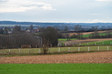 Obraz premium Green meadows and fields at the hills of the Flemish countryside around Leuven, Brabant, Belgium