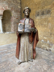 Estatua de bronce que representa a Dante Alighieri sujetando La Divina Comedia. 