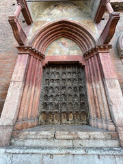 Antiguo portal de madera con arcos románicos en la Catedral de Verona, Italia. 