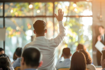 Audience raising hands up while businessman is speaking in training at the office.