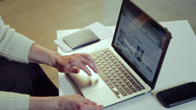 Focus on laptop. Woman using laptop for online reservation, booking hotels via Internet services, choosing places. Concept of vacation, traveling, booking services
