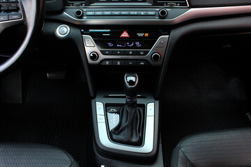 Automatic transmission gear knob. Modern leather interior of the new car. Gear stick with multimedia console. Button for shifting gears on car.
