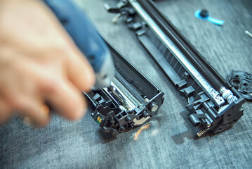 hands repairing laser toner cartridge