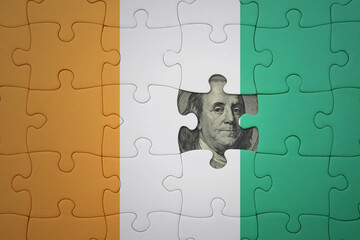 puzzle with the national flag of cote divoire and usa dollar banknote. finance concept