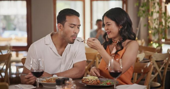 Feed, dating and couple eating in restaurant together for love, romance or anniversary celebration. Smile, fine dining or taste with man and woman sharing at romantic dinner for valentines day date